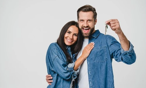 Couple heureux d'avoir les clés de leur habitation grâce à un prêt immobilier