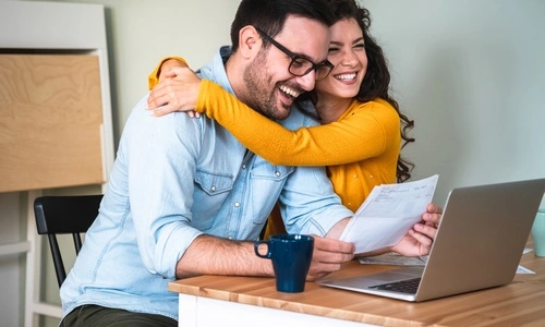Coppia felice che lavora al proprio budget per comprare la casa con un mutuo
