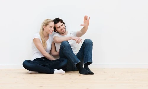 Couple en train d'imaginer leur intérieur de maison après avoir obtenu leur prêt immobilier